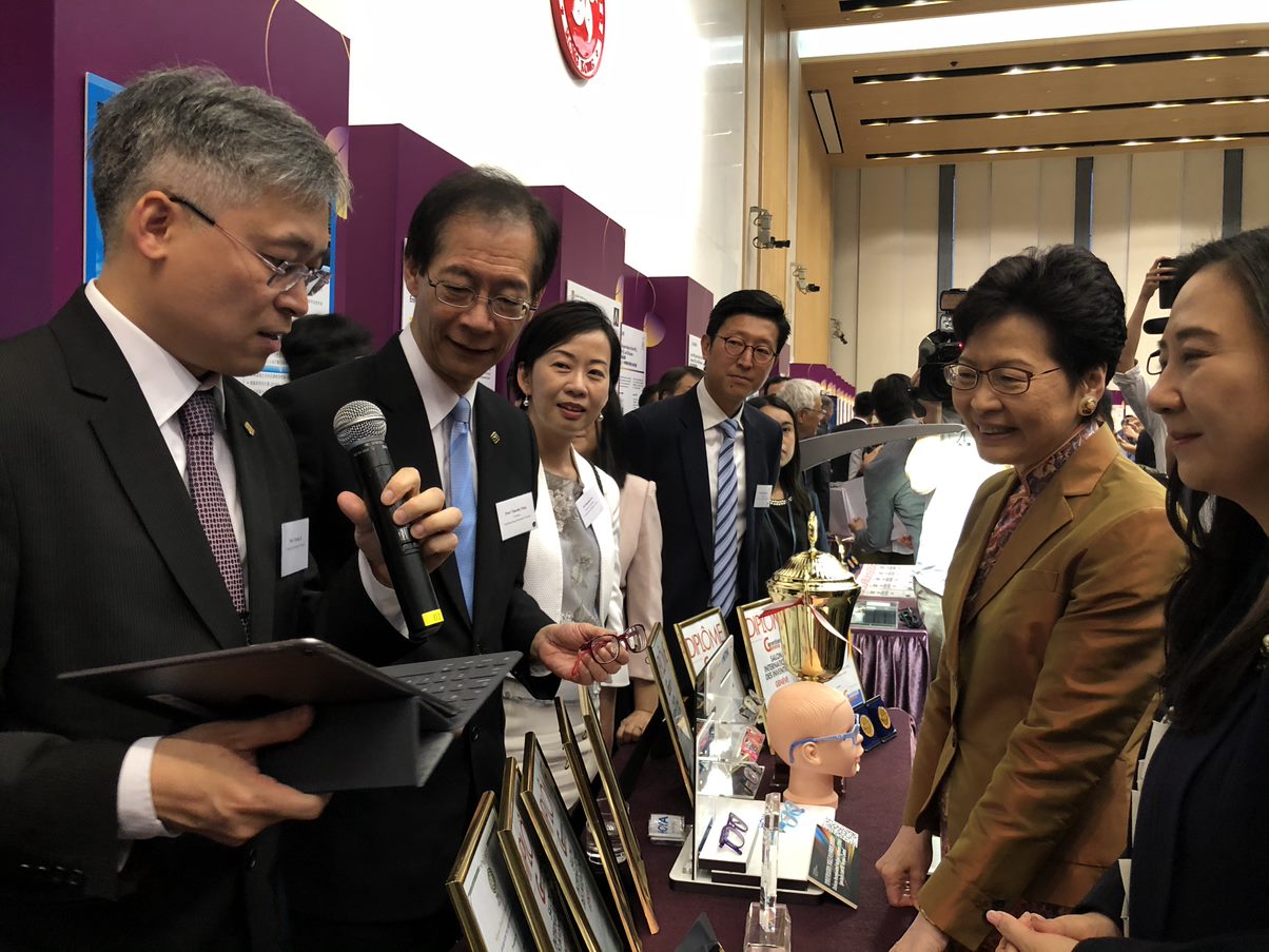 团队于「香港发明 扬威海外」庆祝酒会中，向行政长官林郑月娥讲解 DIMS 镜片的设计意念。